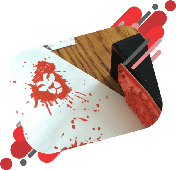 Red Rubber Stamp in the shape of a lion's head with ink spatters